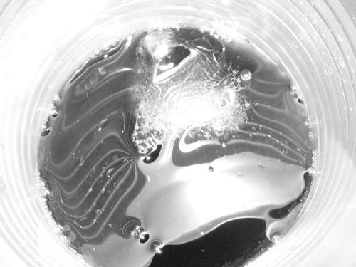 primer plano en blanco y negro de un líquido burbujeante dentro de un vaso